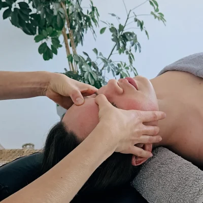 Twarz kobiety masowana masażem kobido.